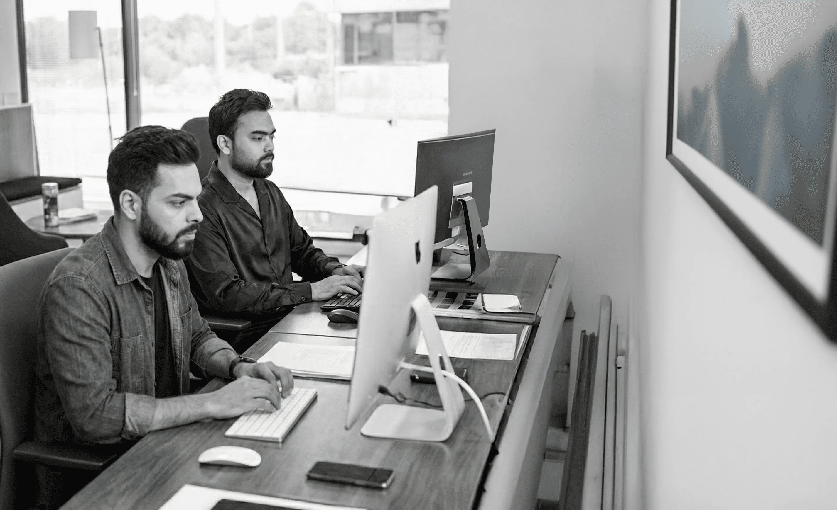 Team of three employees having a meeting at a table in a bright modern office.